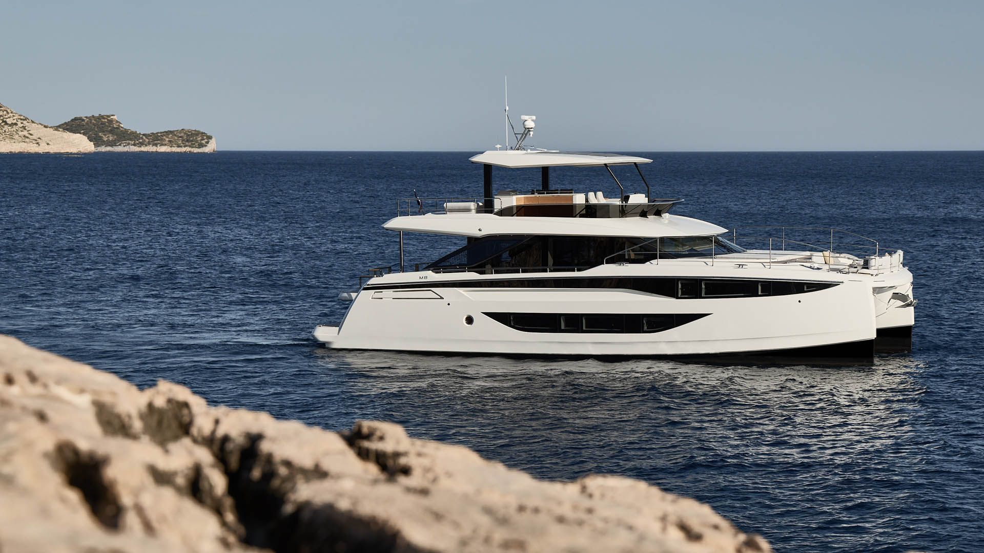 Prestige M8 EVO, witte catamaran varend bij kustlijn