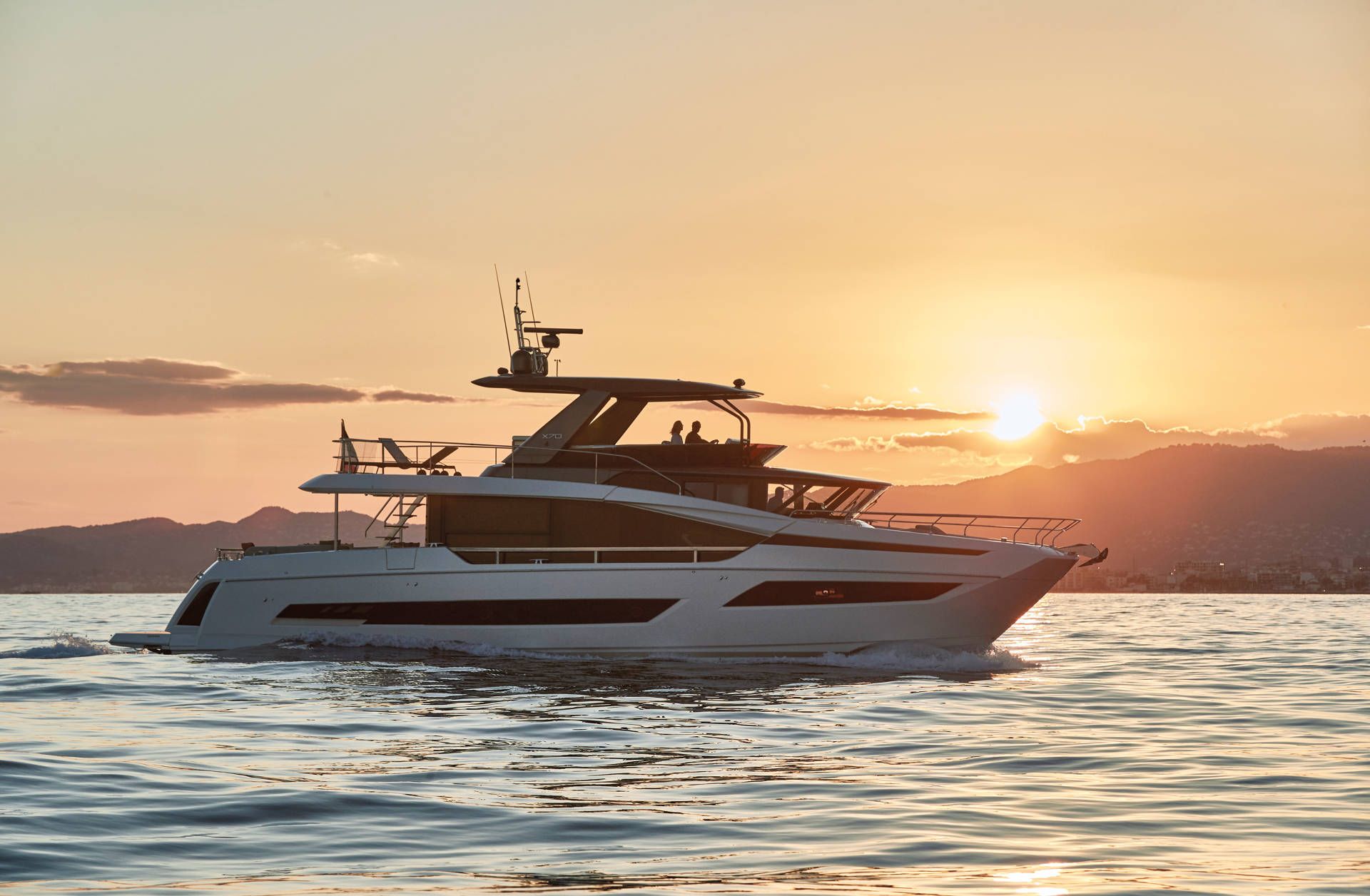 Prestige X70, jacht varend bij zonsondergang