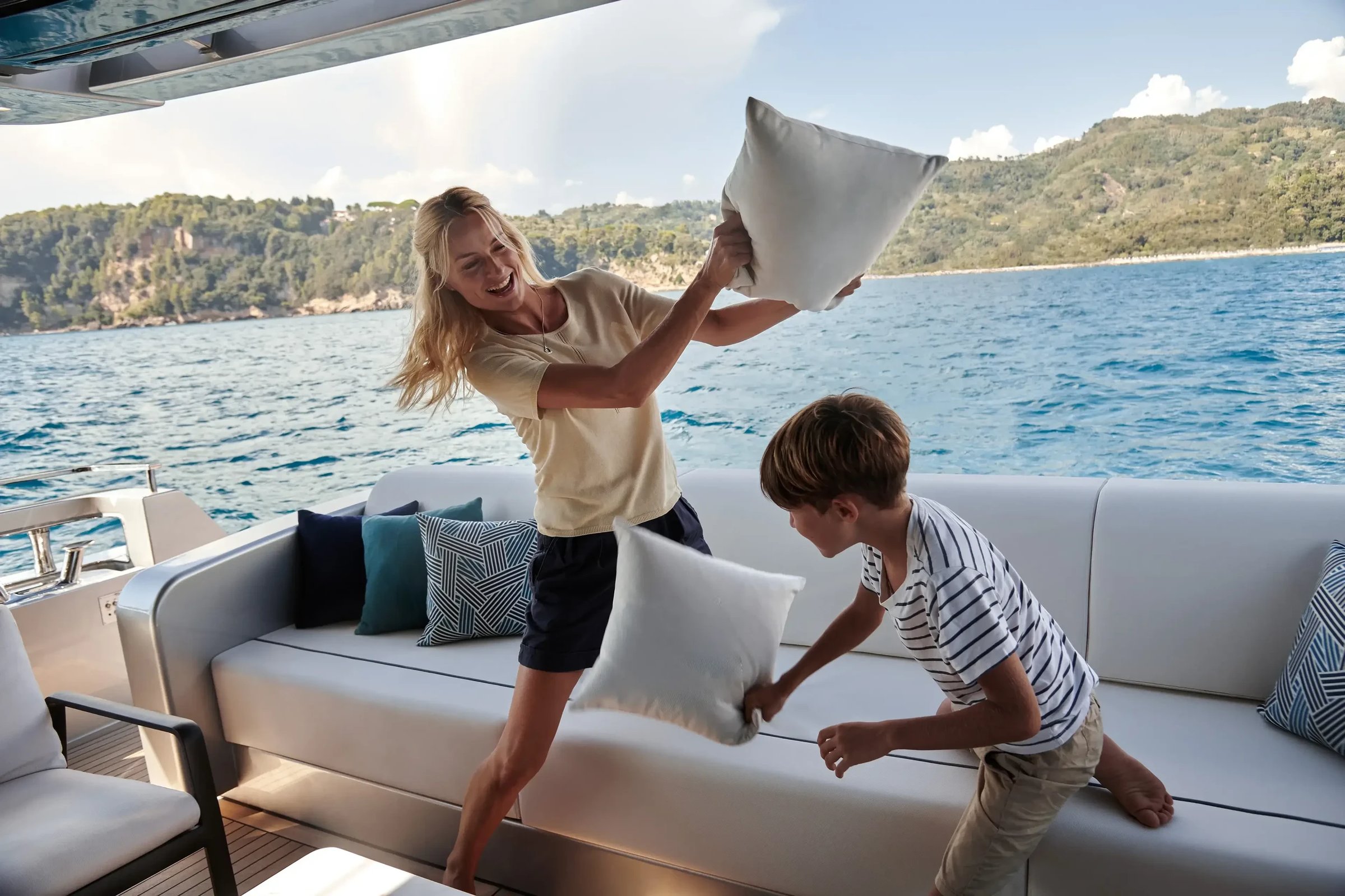 Riva 102' Corsaro Super, moeder en zoon kussengevecht op boot