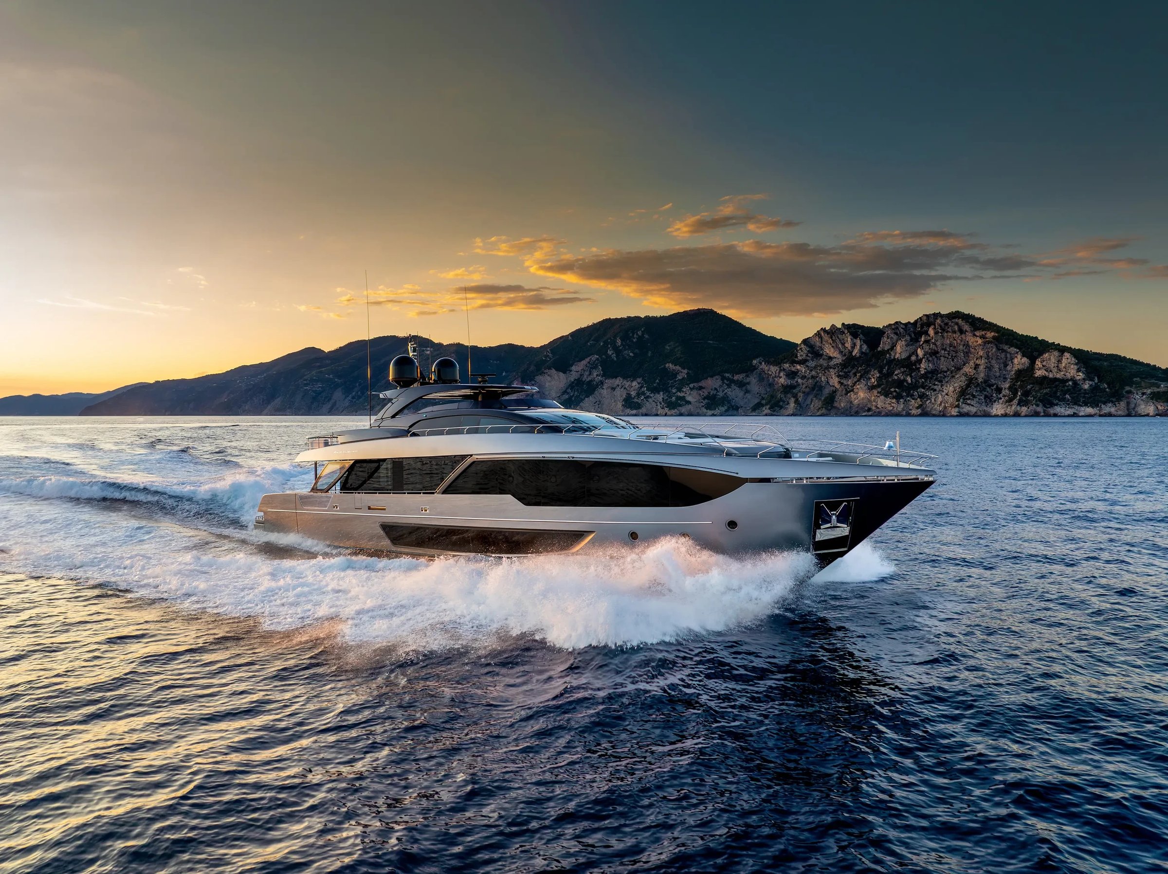 Riva 112' Dolcevita Super New, jacht varend bij zonsondergang
