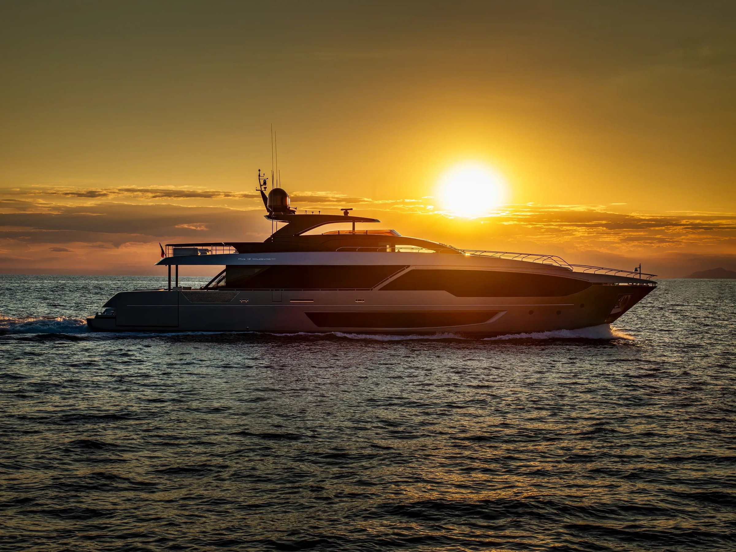 Riva 112' Dolcevita Super New, jacht varend bij zonsondergang