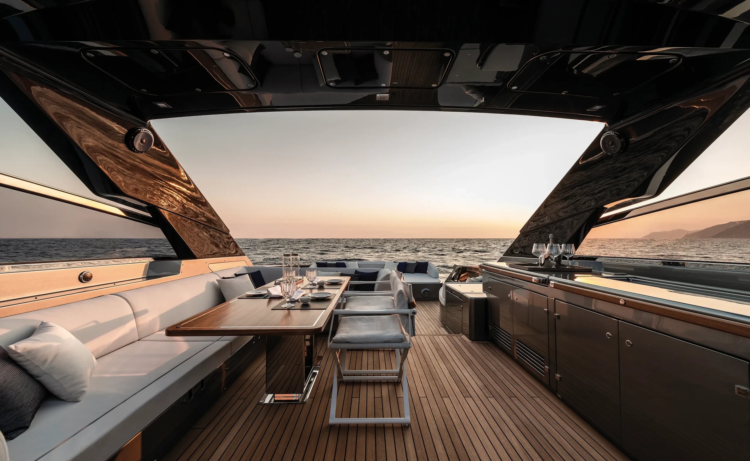 Riva 76' Bahamas Super, achterdek met eettafel en zonsondergang