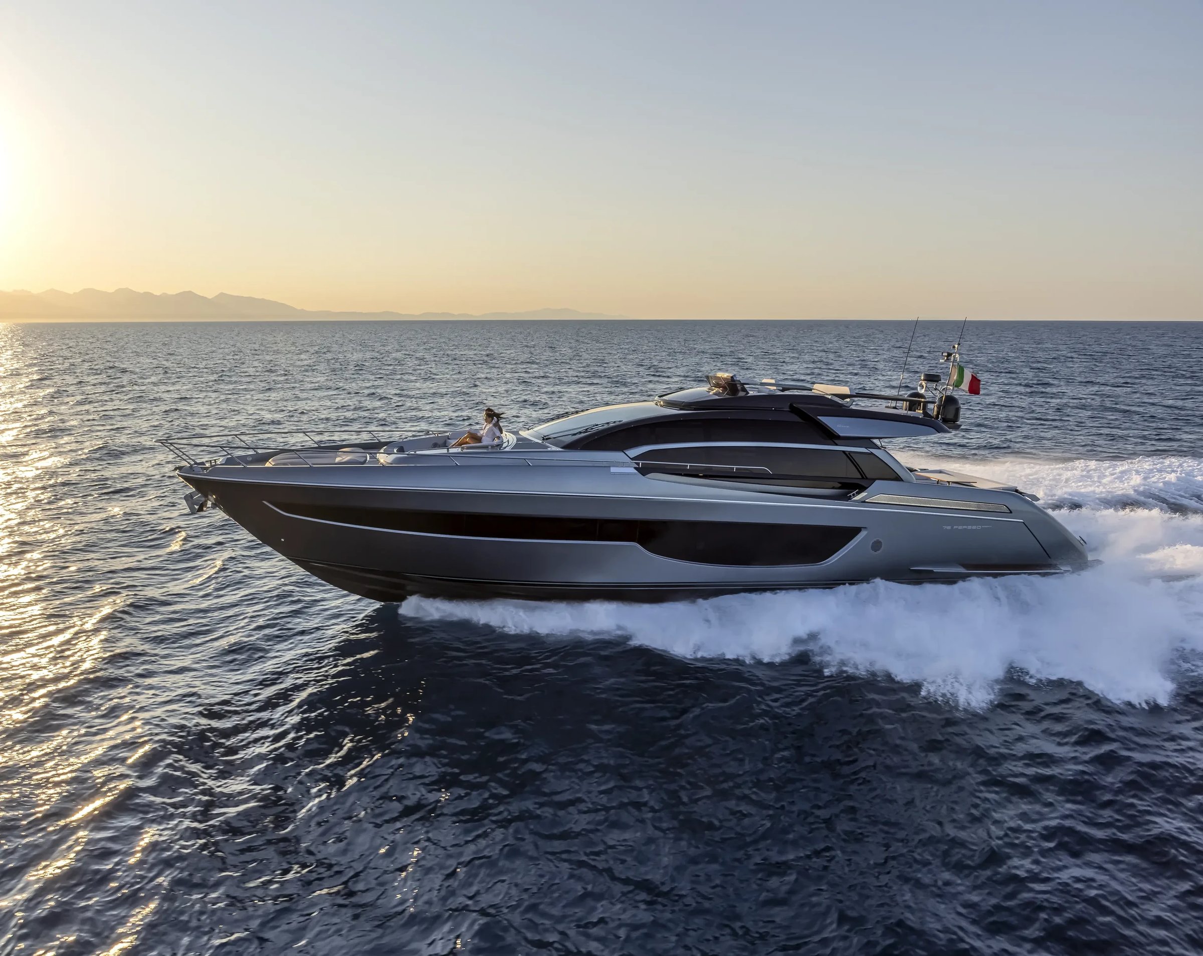 Riva 76' Perseo Super, jacht varend op zee bij zonsondergang