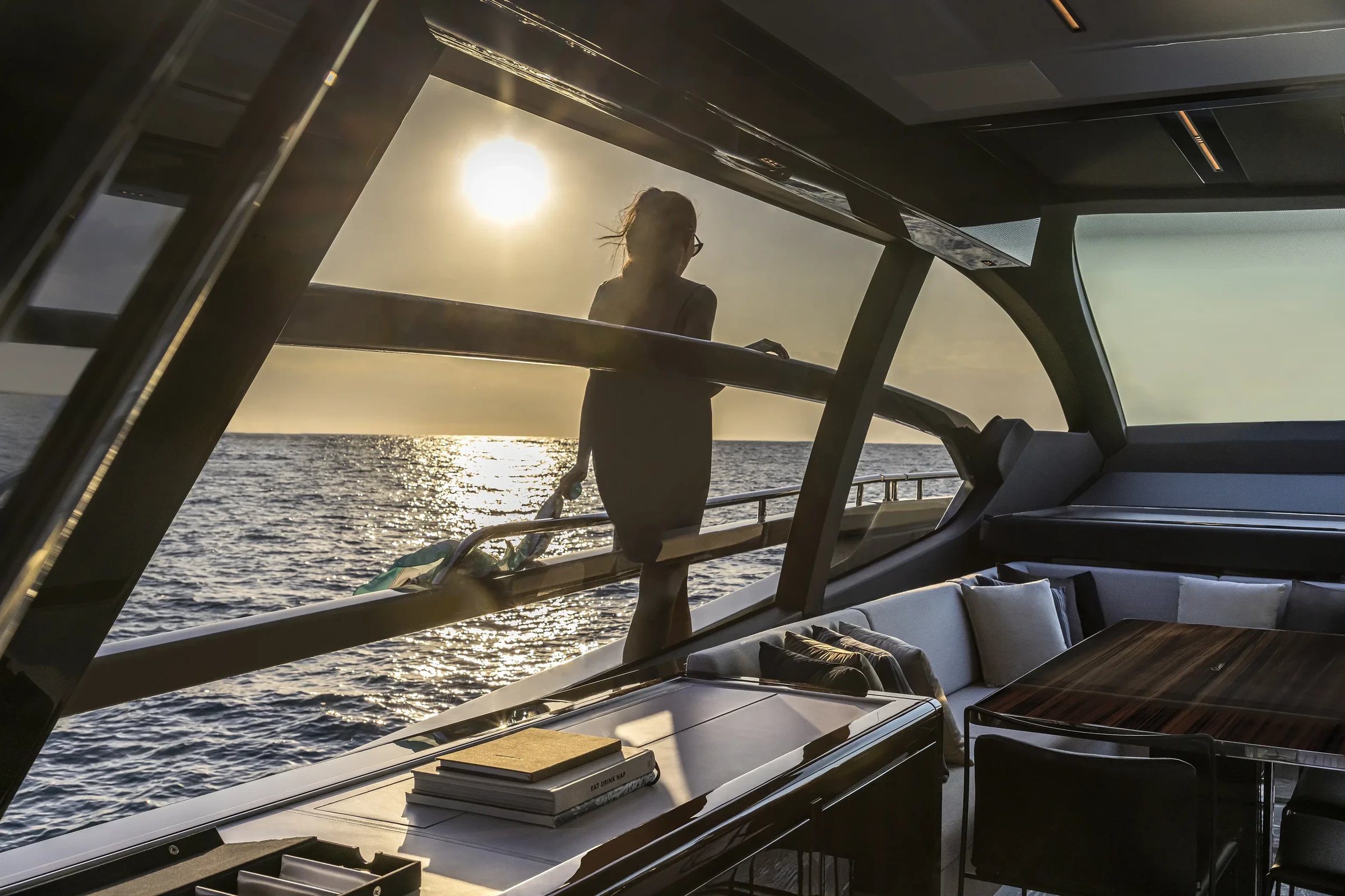 Riva 76' Perseo Super, vrouw kijkt naar zonsondergang op boot