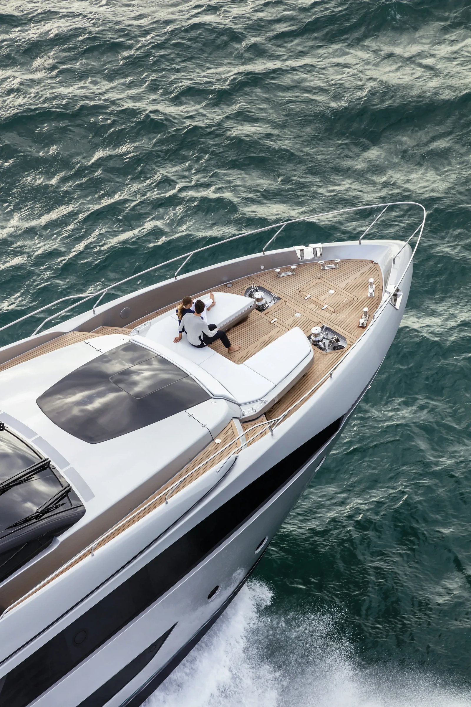 Riva 90' Argo, boot varend op zee met stel op voordek