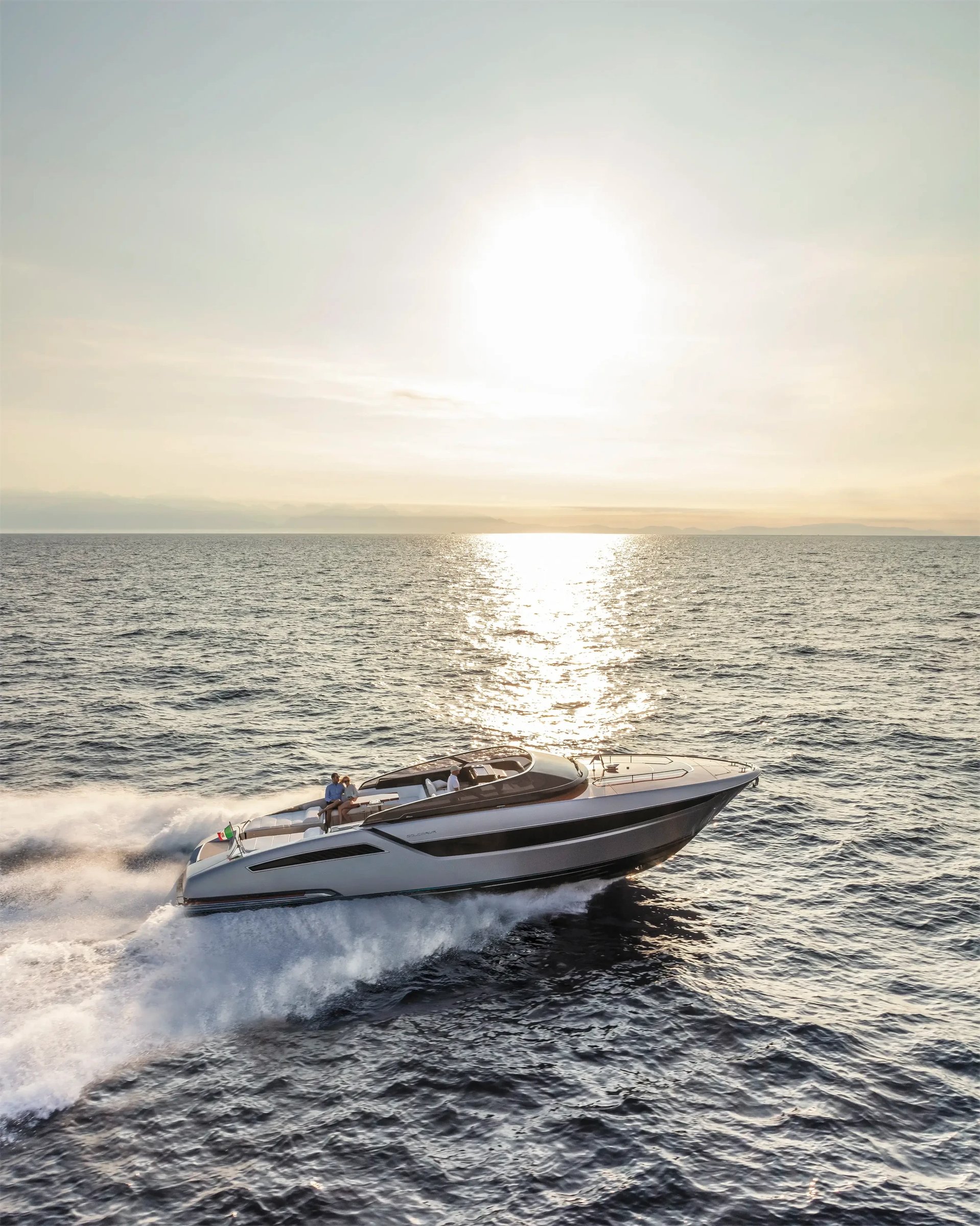 Riva Dolceriva, boot varend op zee bij zonsondergang