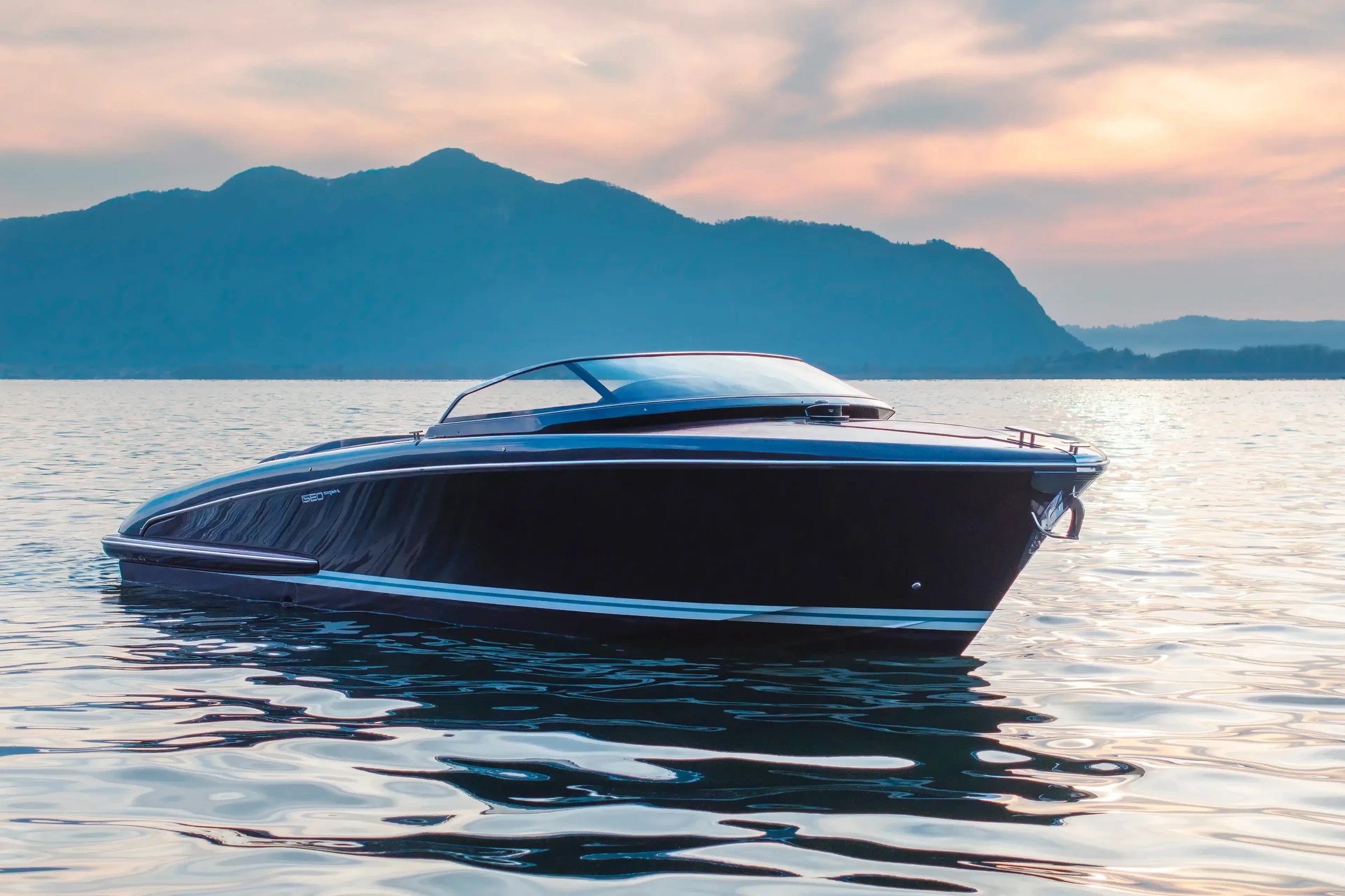 Riva Iseo Super, speedboot drijvend op water bij zonsondergang