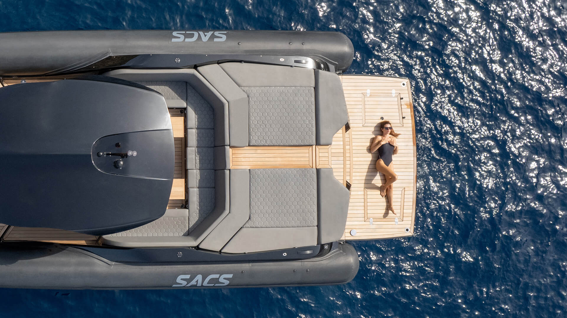 Sacs Marine Strider 15, vrouw ligt zonnend op zwemplatform
