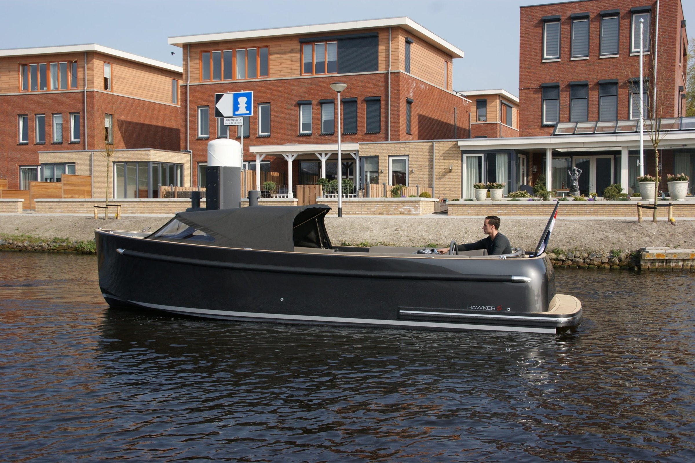 Seafury Tender Hawker 725, zwarte boot vaart door woonwijk
