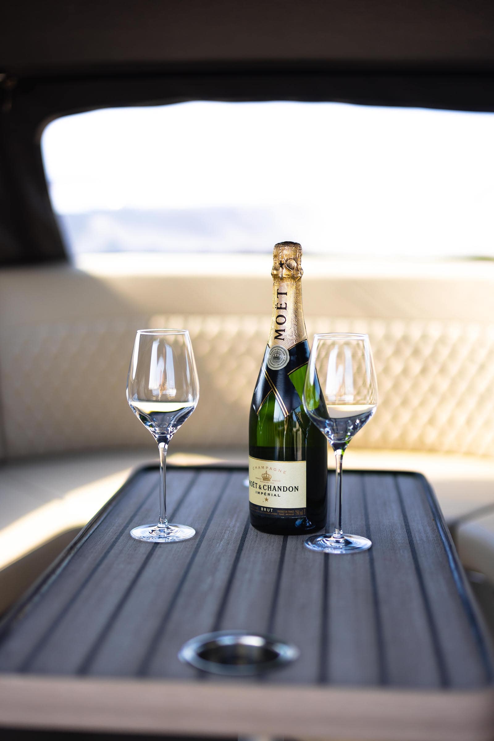 Seafury Tender Hawker 725, champagnefles met twee glazen op tafel