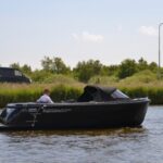 Topcraft 605 Tender, zwarte boot vaart op water