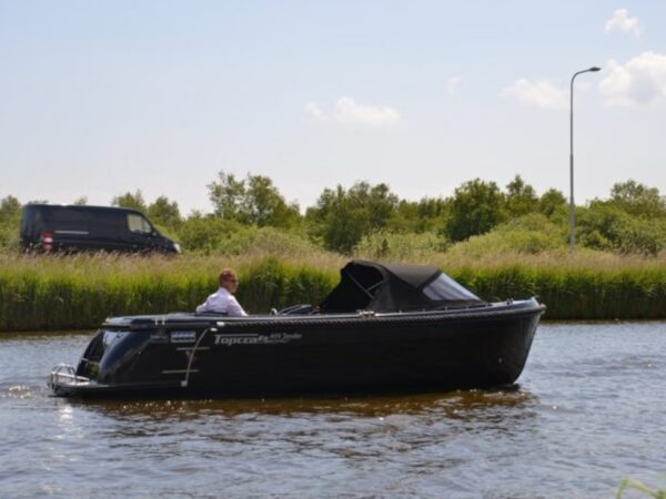 Topcraft 605 Tender, zwarte boot vaart op water