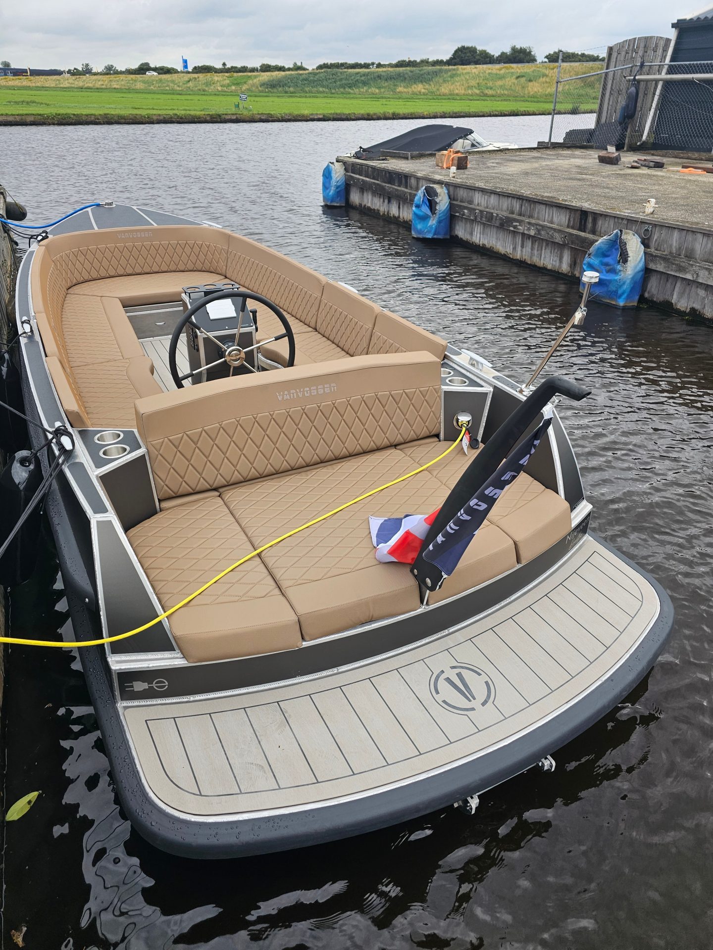 Van Vossen Plugin-E-Tender 595, boot met beige zitbanken afgemeerd