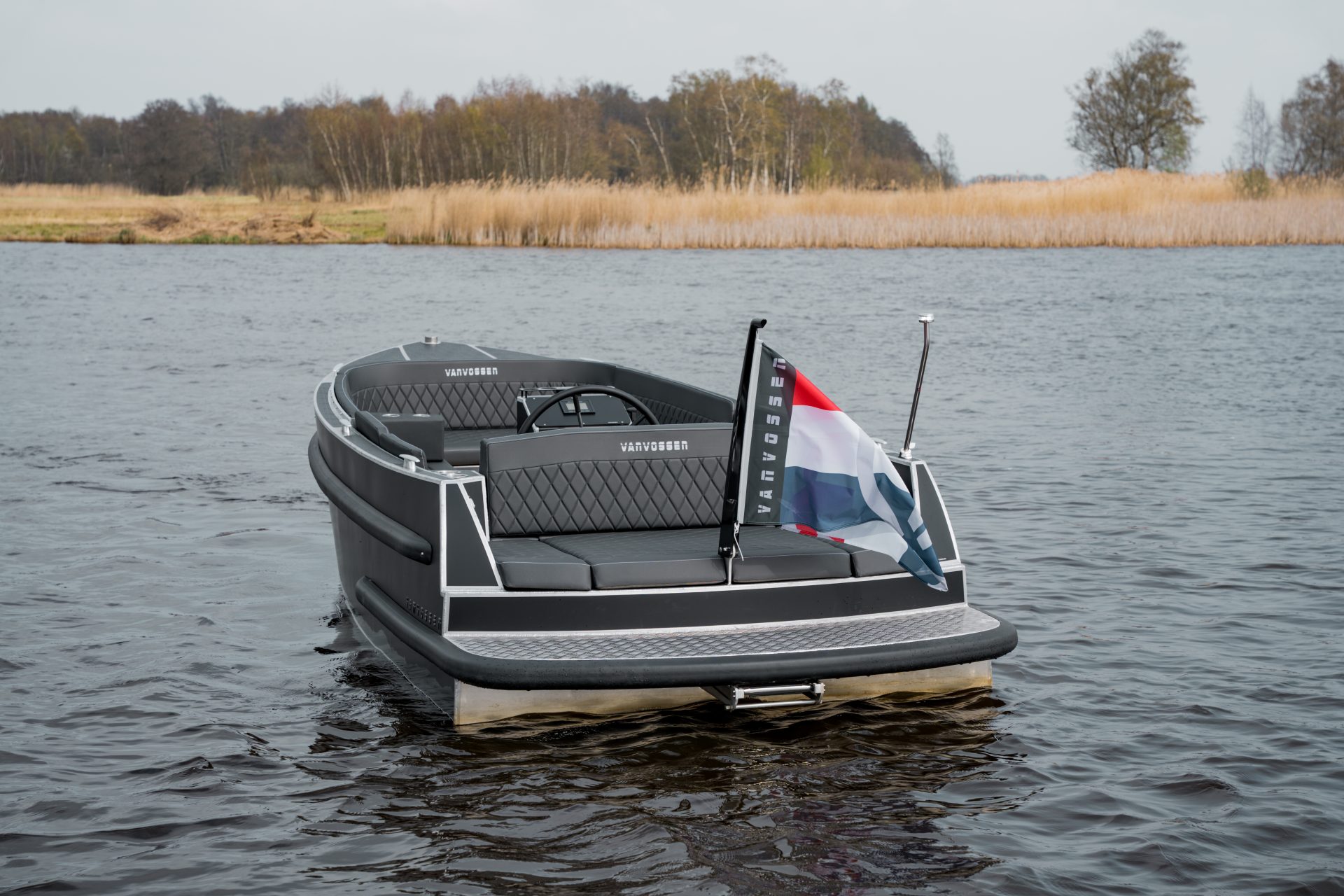 Van Vossen Plugin-E-Tender 595, boot op water met vlag