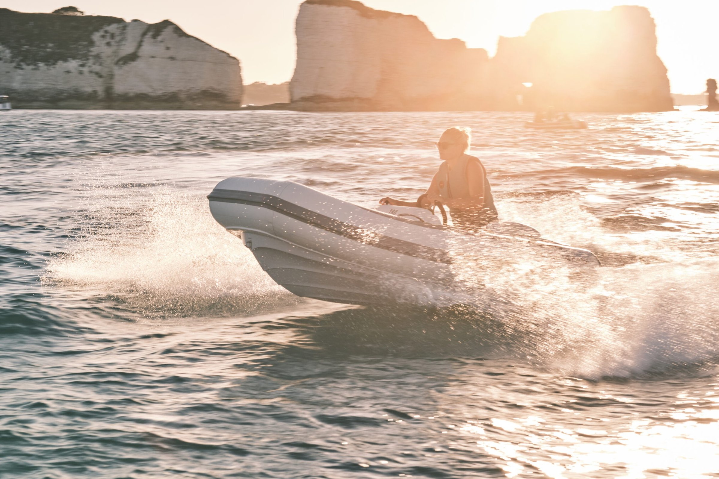 Williams Jet Tenders TurboJet 280MX, rubberboot varend bij kliffen zonsondergang