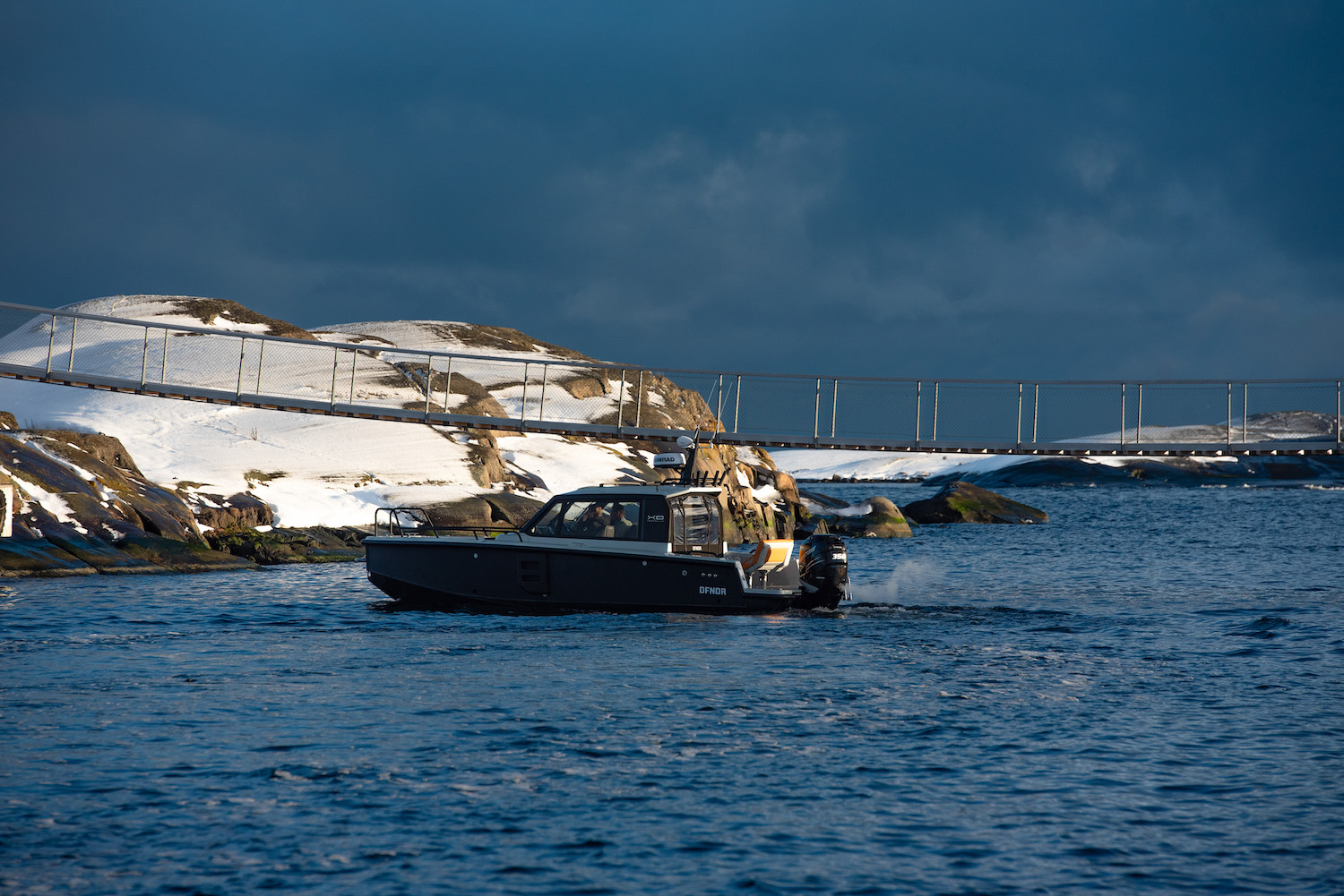 XO DFNDR 8, boot varend bij besneeuwde kust