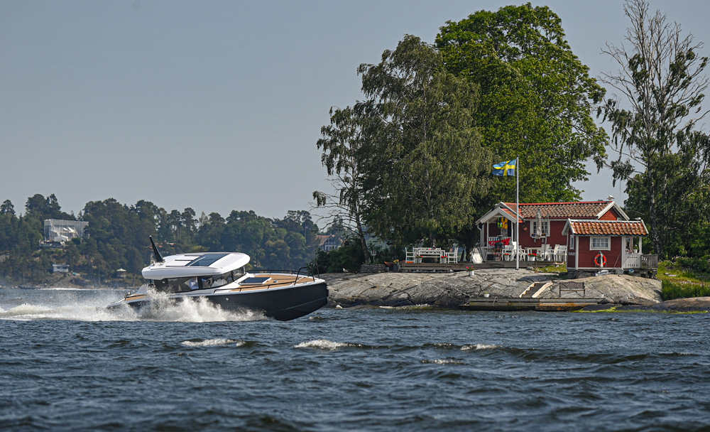 XO EXPLR 10 Sport+ IB, boot varend nabij rood huisje